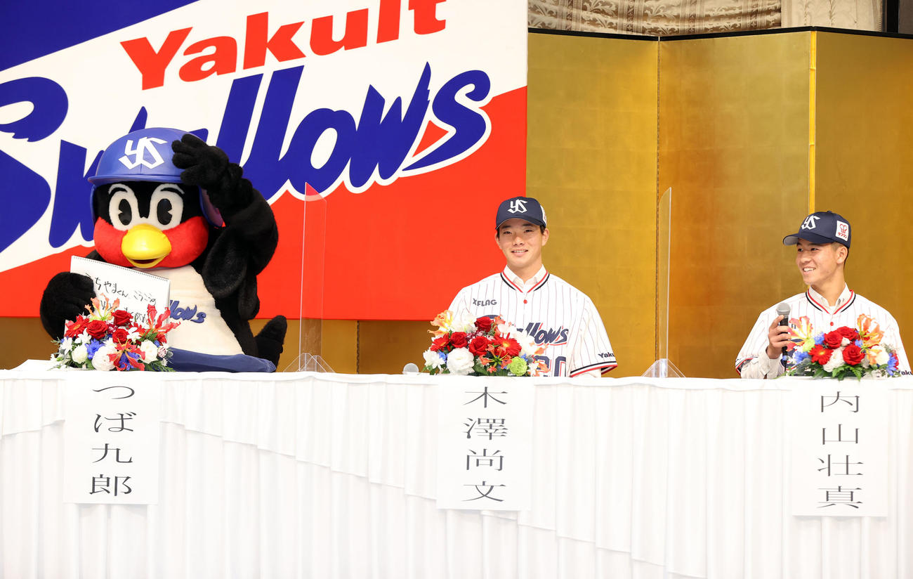 ヤクルト新入団発表会見で、つば九郎から「こうこうのかずかんとく、おくがわくんからつばくろうのへんなこと聞いてないよね？」と質問され、「『気を付けろ！』と言われています」と切り返すドラフト3位星稜・内山（右）。中央は1位慶大・木沢（撮影・狩俣裕三）
