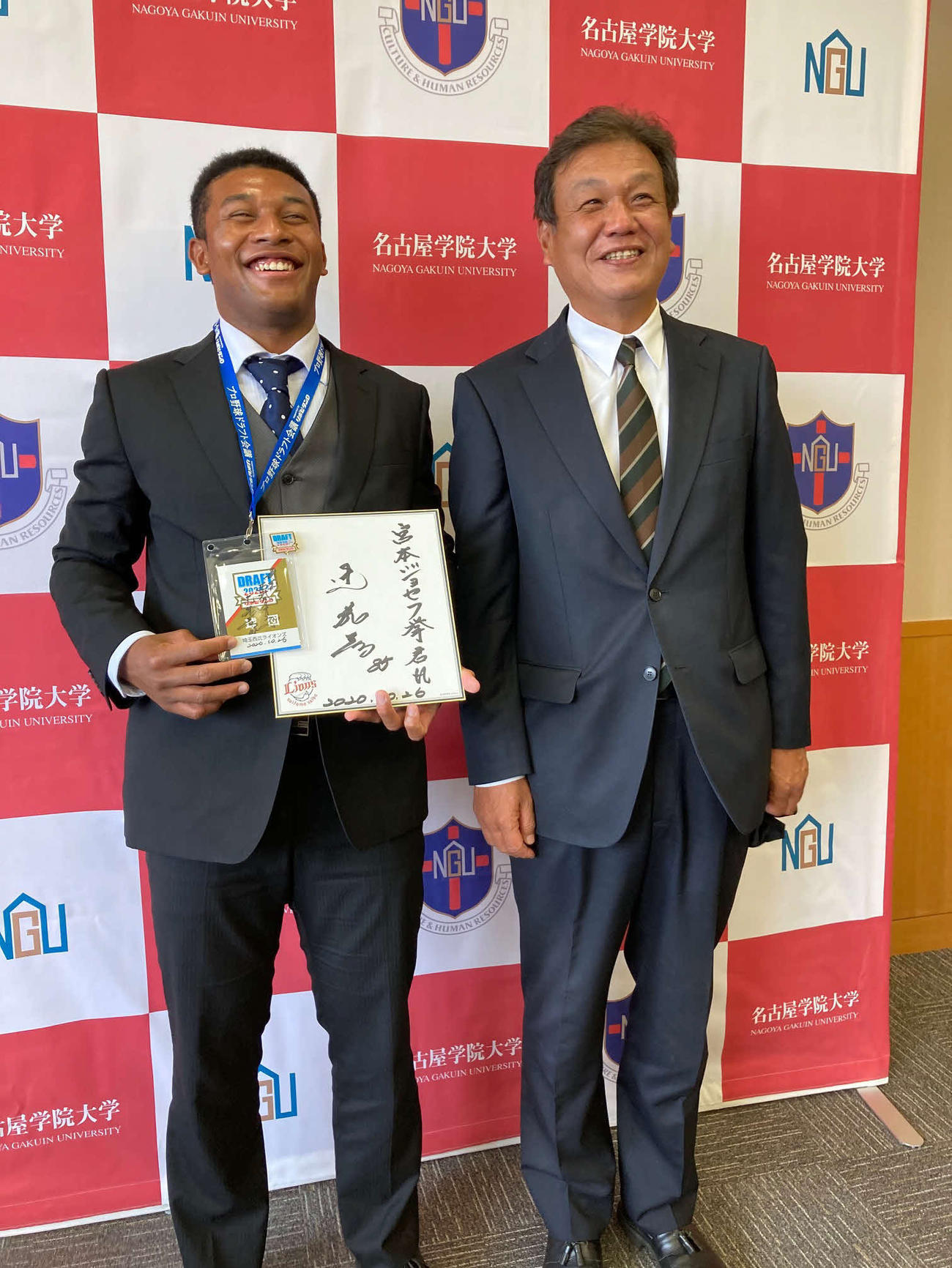 西武に育成ドラフト3位で指名された宮本ジョセフ拳外野手(左)と記念撮影する名古屋学院大の金田進監督