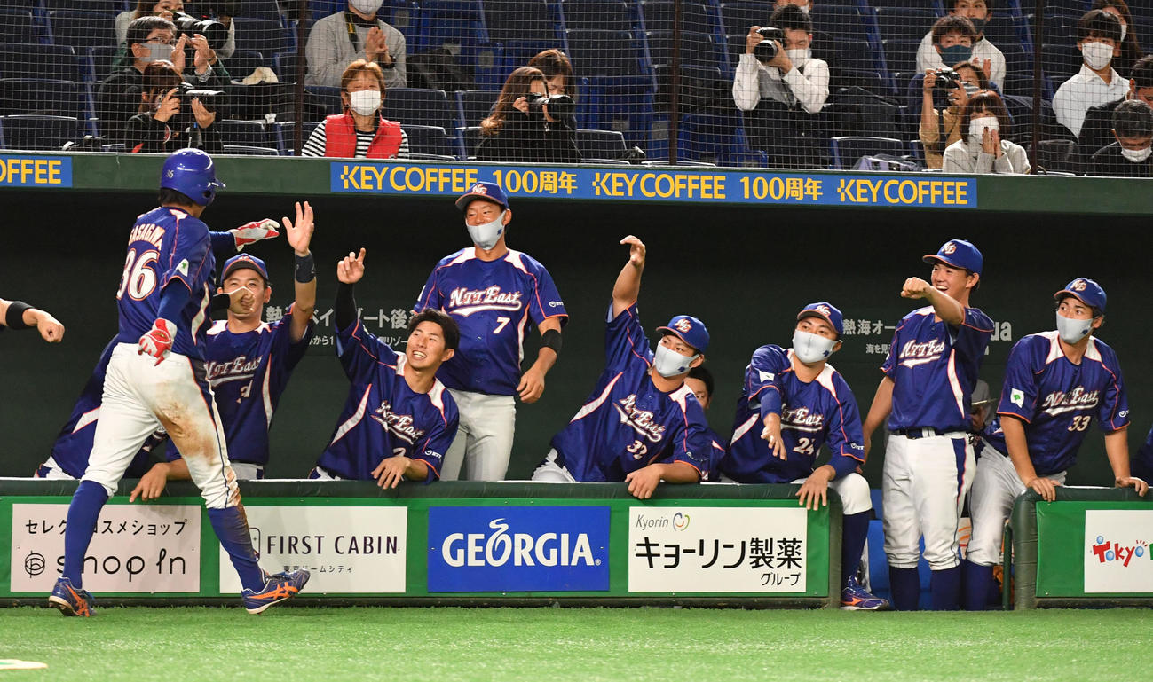 決勝NTT東日本対ホンダ　2回表NTT東日本1死二塁、喜納の右前適時打で二塁走者笹川が生還しナインの出迎えを受ける（撮影・柴田隆二）
