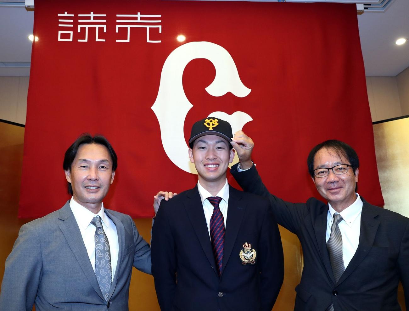 仮契約を結び、記念撮影を行う巨人ドラフト2位東海大・山崎（中央）と榑松スカウト部次長（左）と内田担当スカウト（球団提供）