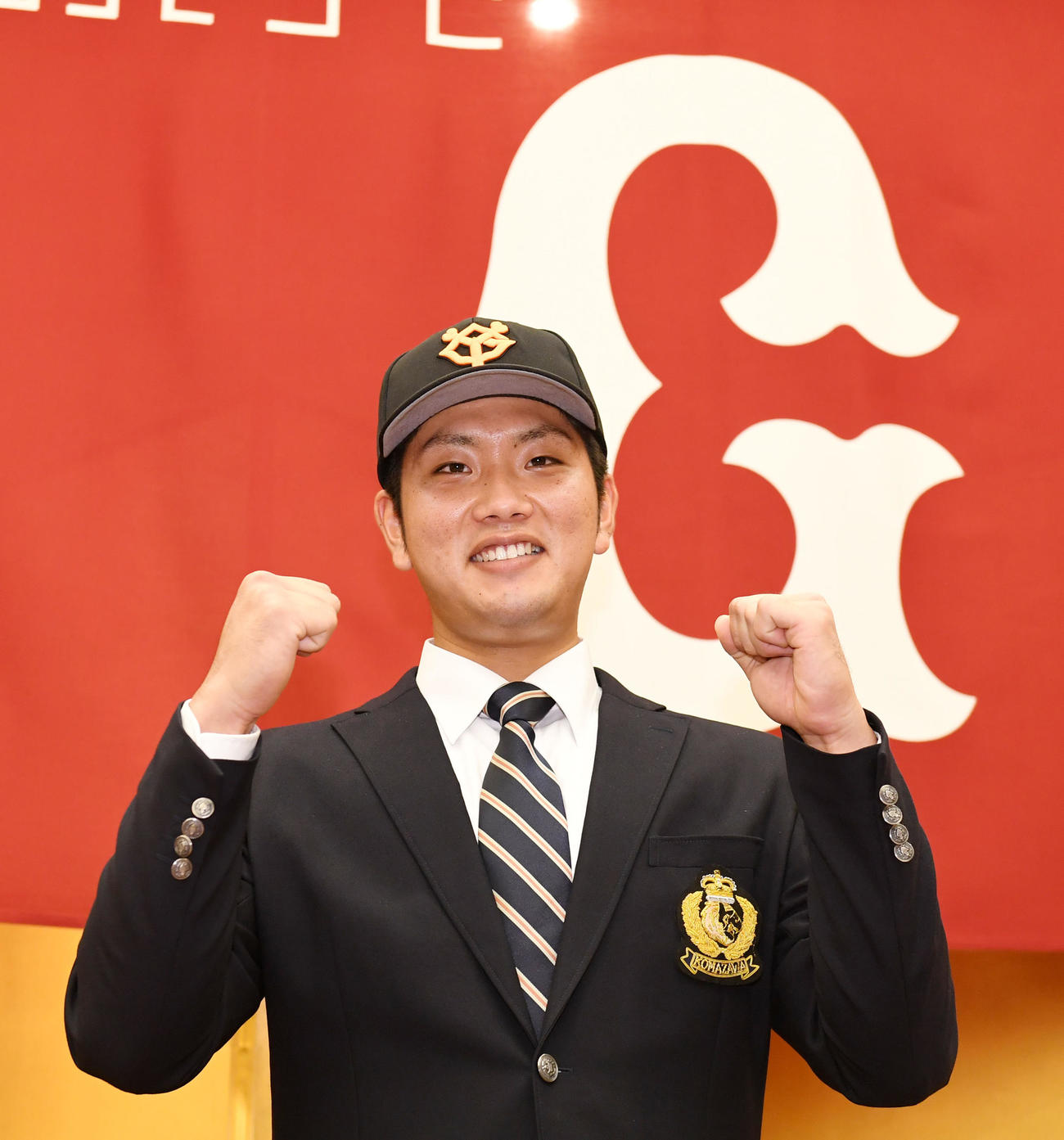 巨人と仮契約を結び笑顔でガッツポーズするドラフト育成5位の駒大・前田（撮影・横山健太）