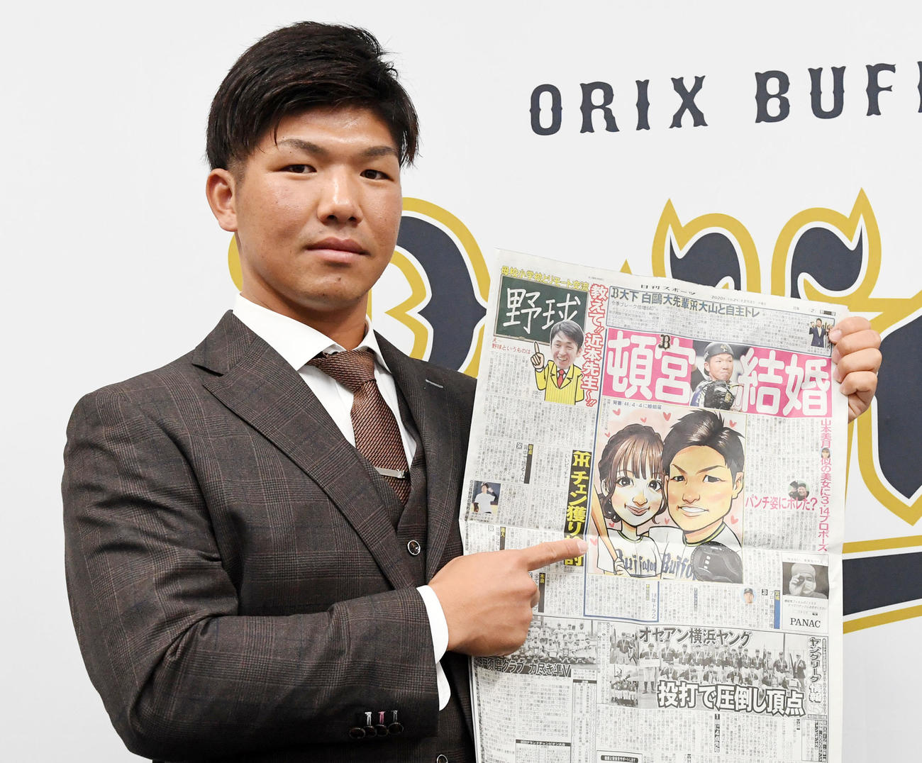 ダウンで契約更改の頓宮は結婚を伝える本紙を手に来シーズンの活躍を誓う（撮影・前岡正明）