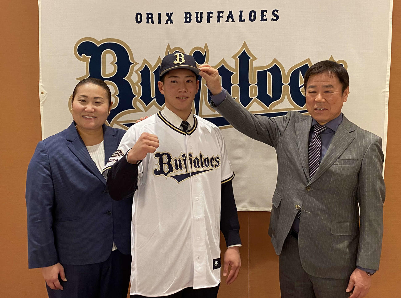 オリックスと仮契約を結んだ明石商・来田涼斗は福良GM（右）に帽子をかぶせてもらいガッツポーズ。左は乾スカウト（撮影・真柴健）