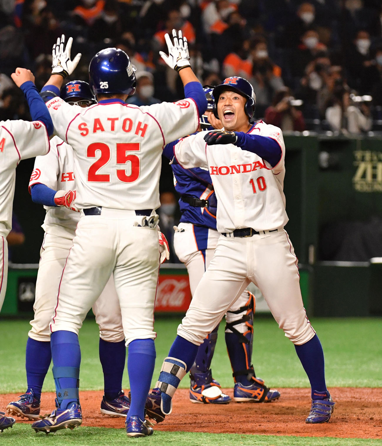 NTT東日本対ホンダ　5回裏ホンダ1死一、二塁、井上（右）は右越えに本塁打を放ちナインの出迎えを受ける（撮影・柴田隆二）
