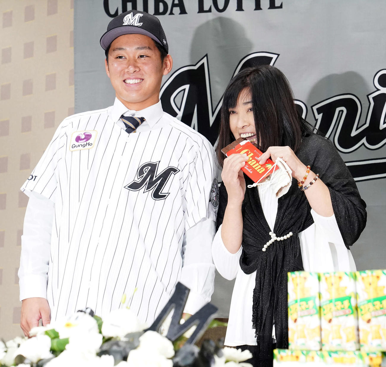 ロッテと仮契約を結んだドラフト1位の法大・鈴木（左）の横でチョコレートを食べようとする母広江さん（撮影・江口和貴）