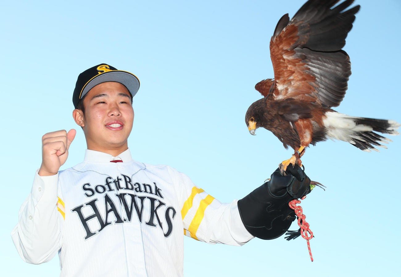 ソフトバンク1位指名の花咲徳栄・井上はハリスホークを手に笑顔を見せる（撮影・足立雅史）