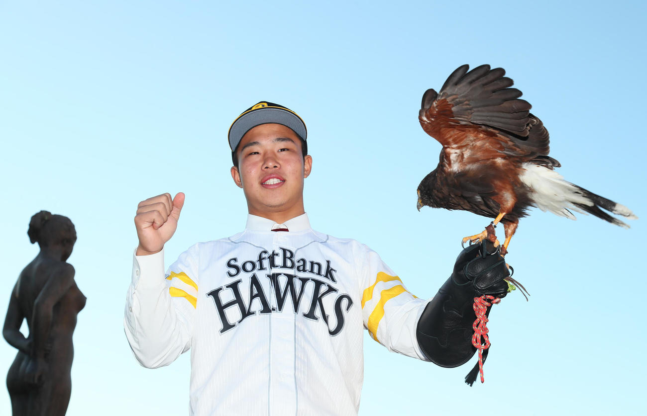 ソフトバンク1位指名の花咲徳栄・井上はハリスホークを手に笑顔を見せる（撮影・足立雅史）