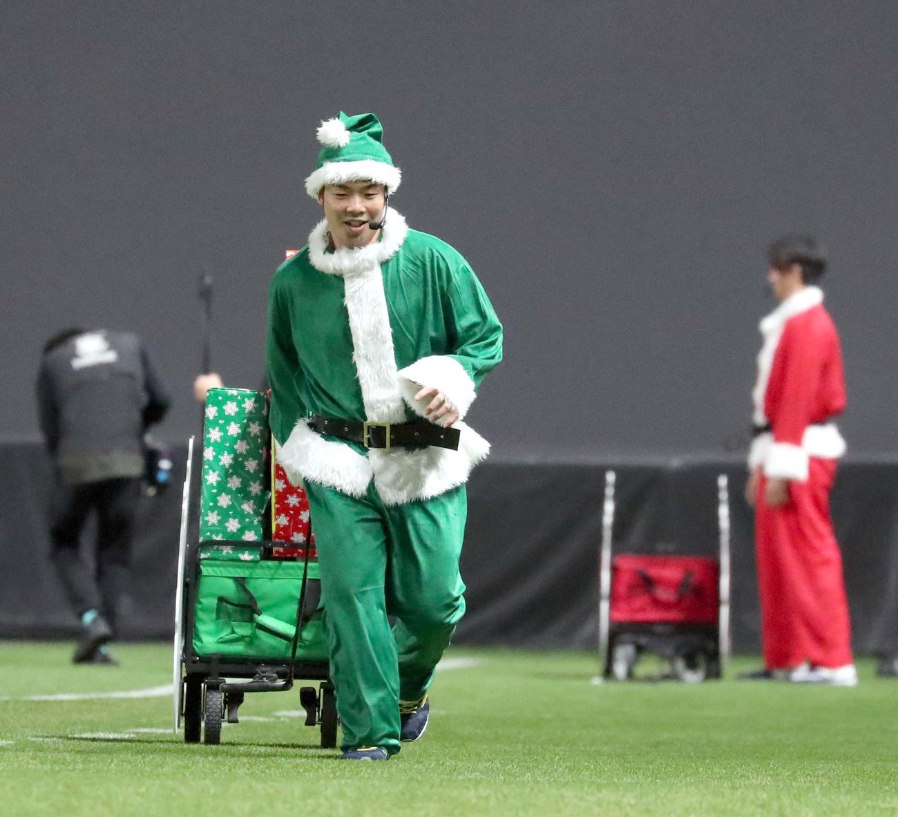 クリスマスリレーバトルでサンタの格好でプレゼントを運ぶ日本ハム近藤（撮影・佐藤翔太）