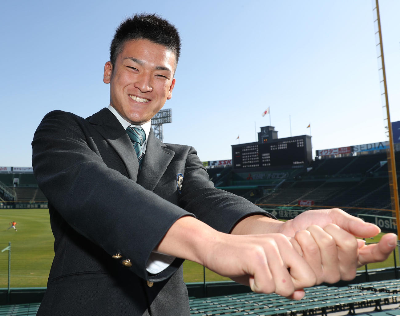 甲子園球場の施設見学を行い笑顔でポーズを決める高寺（撮影・前田充）