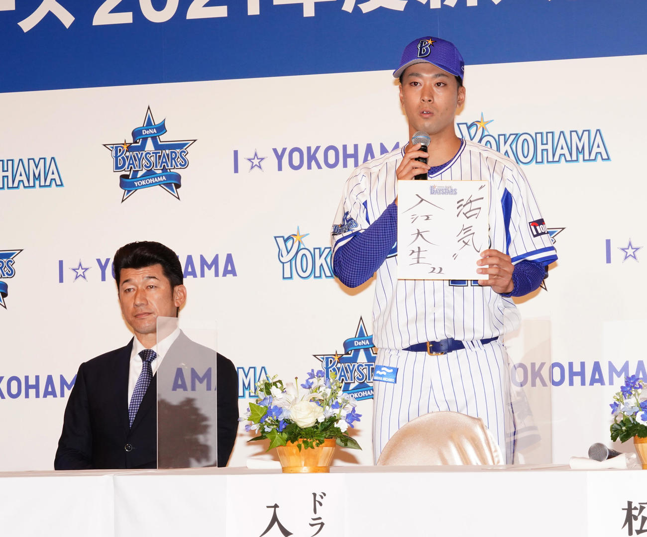 DeNA新入団会見で色紙に「活気」と記し、話をする1位の明大・入江大生（右）。左は三浦大輔新監督（代表撮影）
