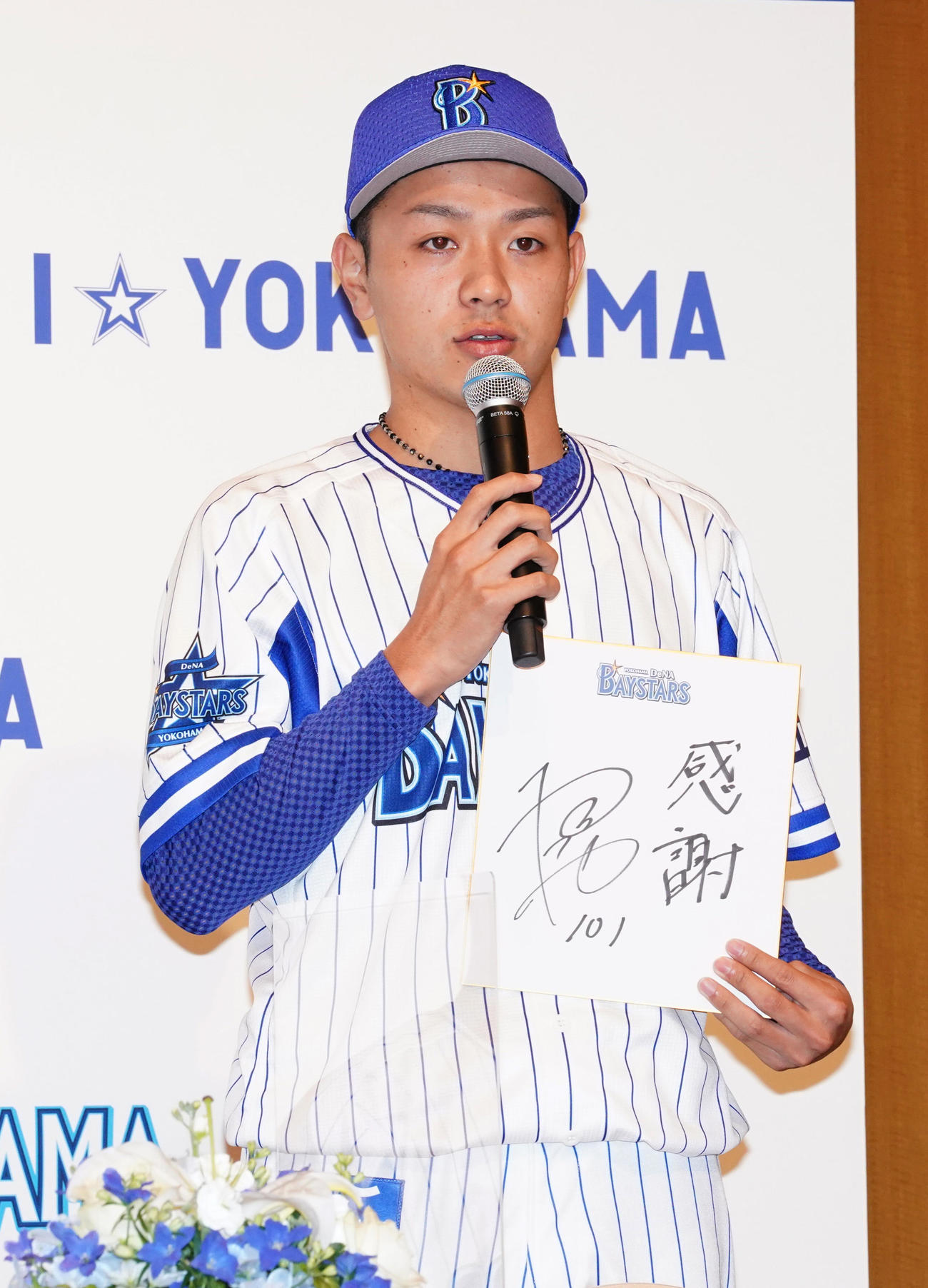 DeNA新入団会見で色紙に「感謝」と記し、話をする育成1位の法大・石川達也（代表撮影）