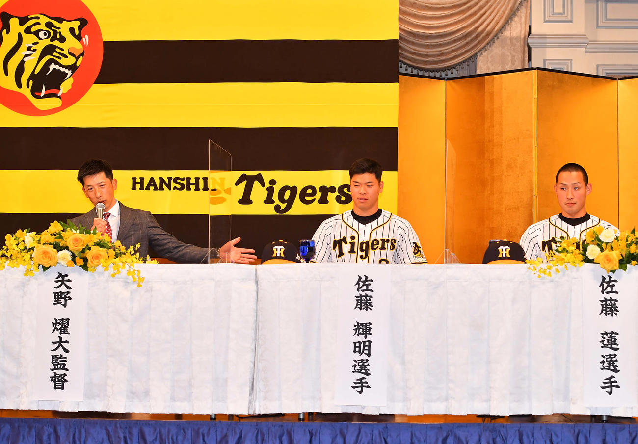 新人選手入団発表会で矢野監督（左）の話を聞く佐藤輝（中央）と佐藤蓮（撮影・上田博志）