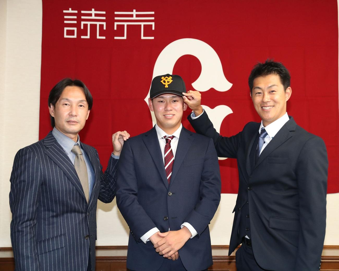 仮契約を結び、笑顔を見せる伊藤優輔（中央）と榑松スカウト部次長（左）、円谷スカウト（右）（球団提供）