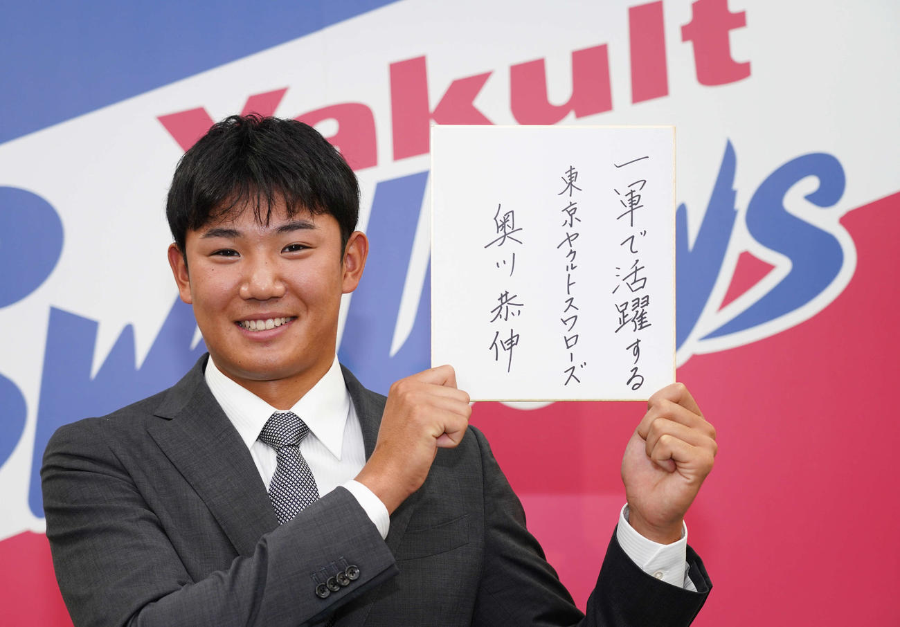 契約更改交渉を終え、来季の目標を記した色紙を手にするヤクルト奥川（代表撮影）