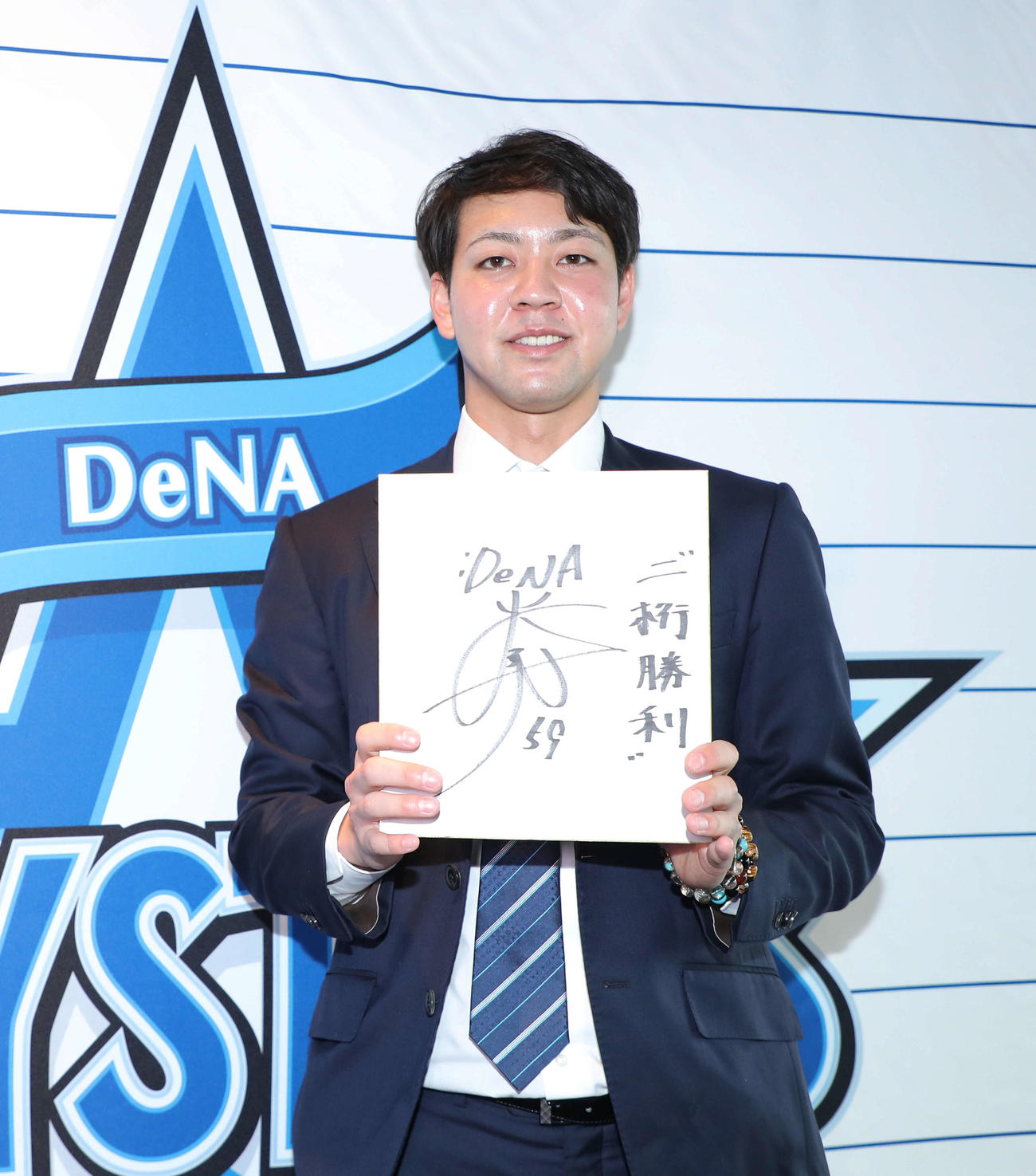 契約更改交渉を終え、来季の目標を記した色紙を手に写真に納まるDeNA平良（代表撮影）