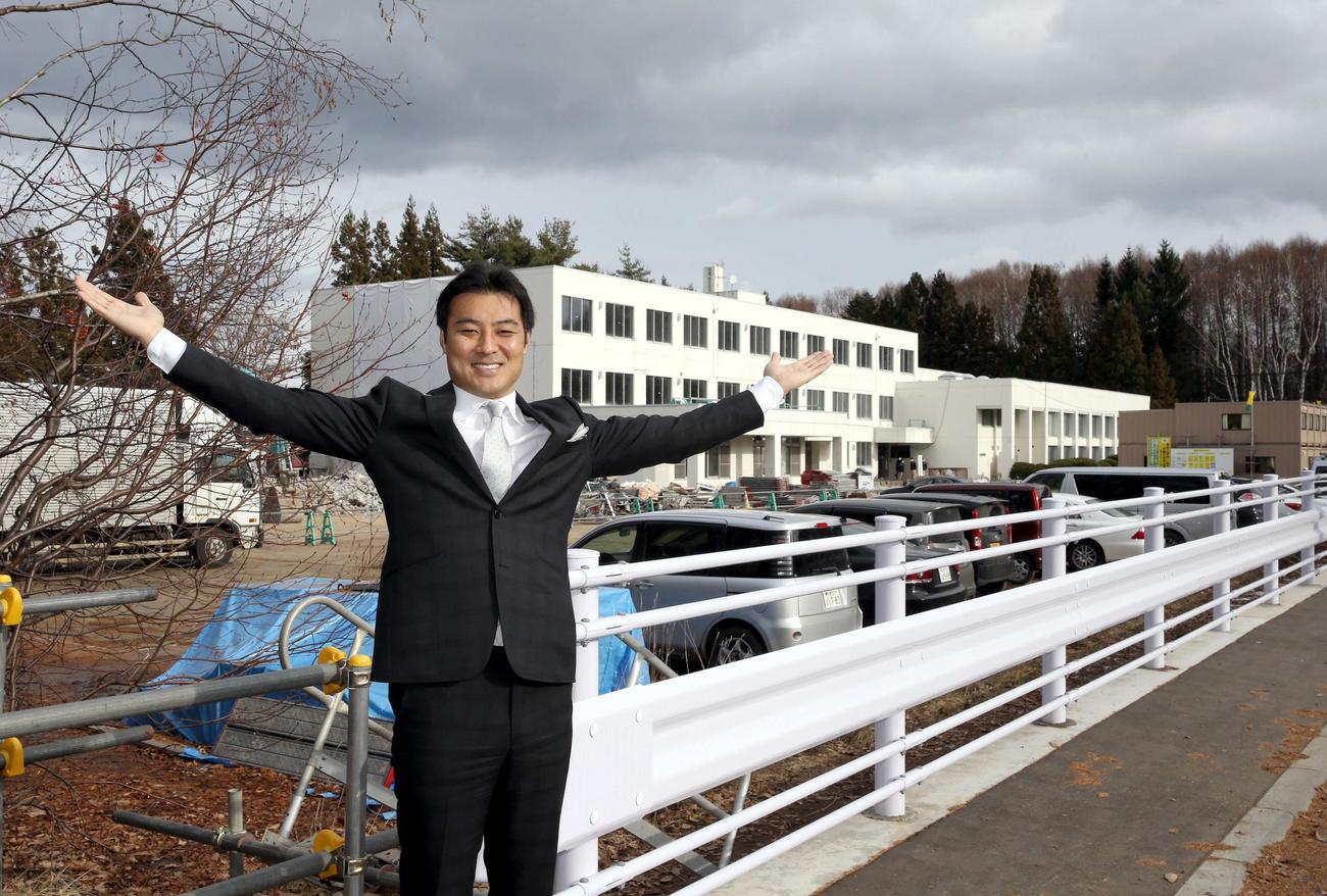 田中学園立命館慶祥小学校の起工式を終え建設予定地を背に笑顔で撮影に応じる日本ハムSAも務める田中理事長（撮影・佐藤翔太）