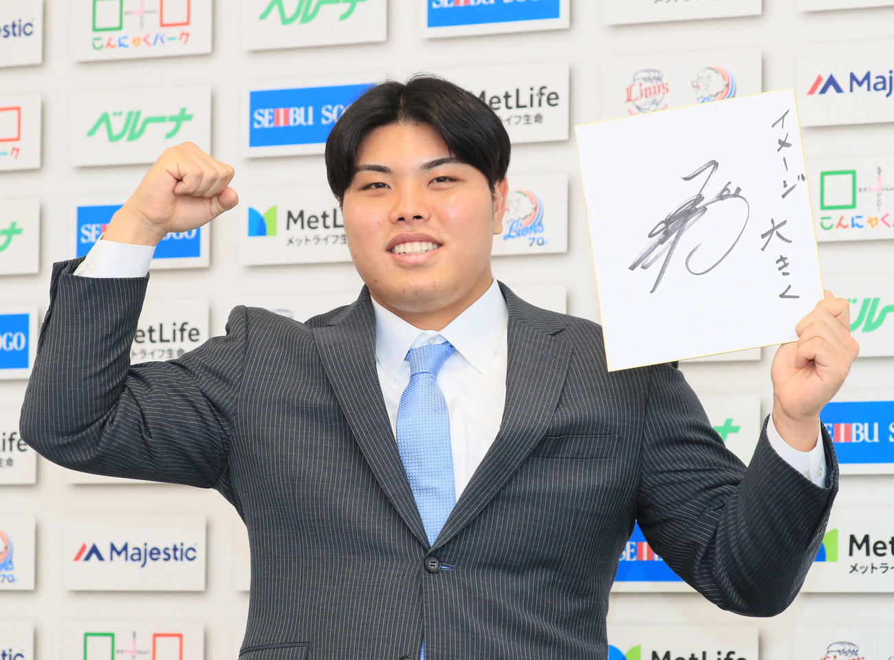 来季の目標を記した色紙を手に笑顔を見せる西武平良（代表撮影）