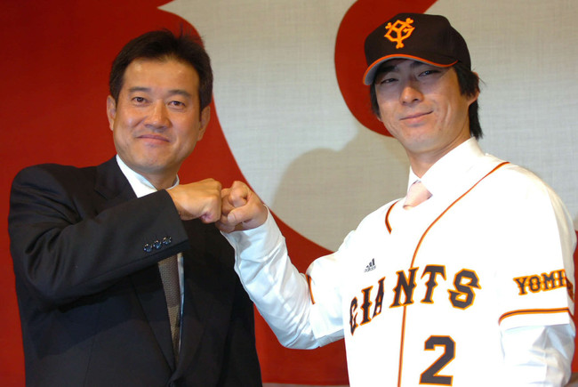 2006年12月4日、巨人のユニホームに腕を通した小笠原道大はトレードマークのひげをそり落とし原辰徳監督とグータッチ