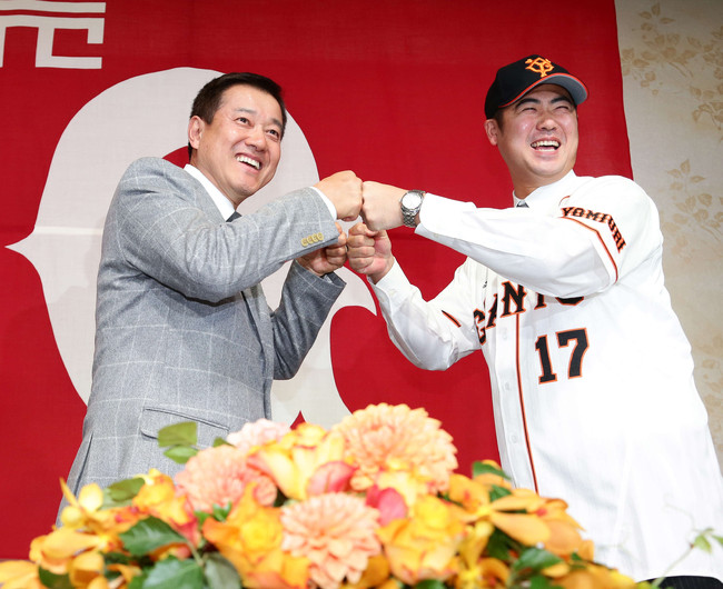 2013年12月4日、巨人入団会見で原辰徳監督（左）とグータッチをかわし満面の笑みを浮かべる大竹寛
