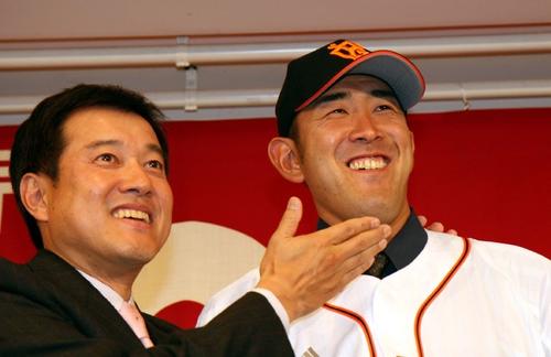 2006年12月11日、巨人への移籍が決定した門倉健(右)は原辰徳監督から大事そうにアゴをさすられ笑顔