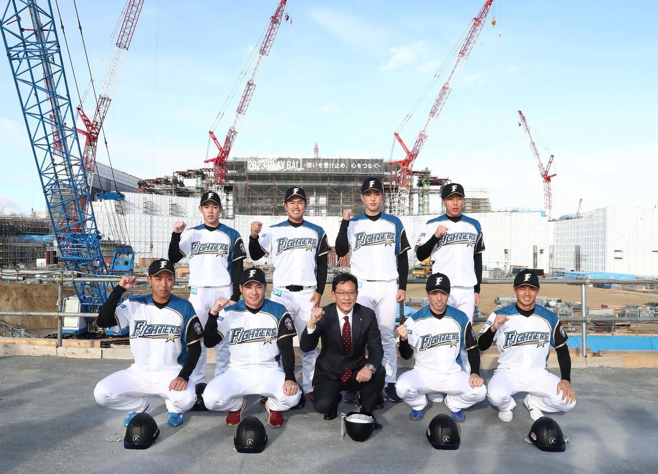 建設中の新球場を背に意気込む日本ハムの新入団選手たち。前列左から、3位古川、1位伊藤、栗山監督、2位五十幡、4位細川、後列左から5位根本、6位今川、育成1位松本遼、育成2位斉藤（撮影・黒川智章）