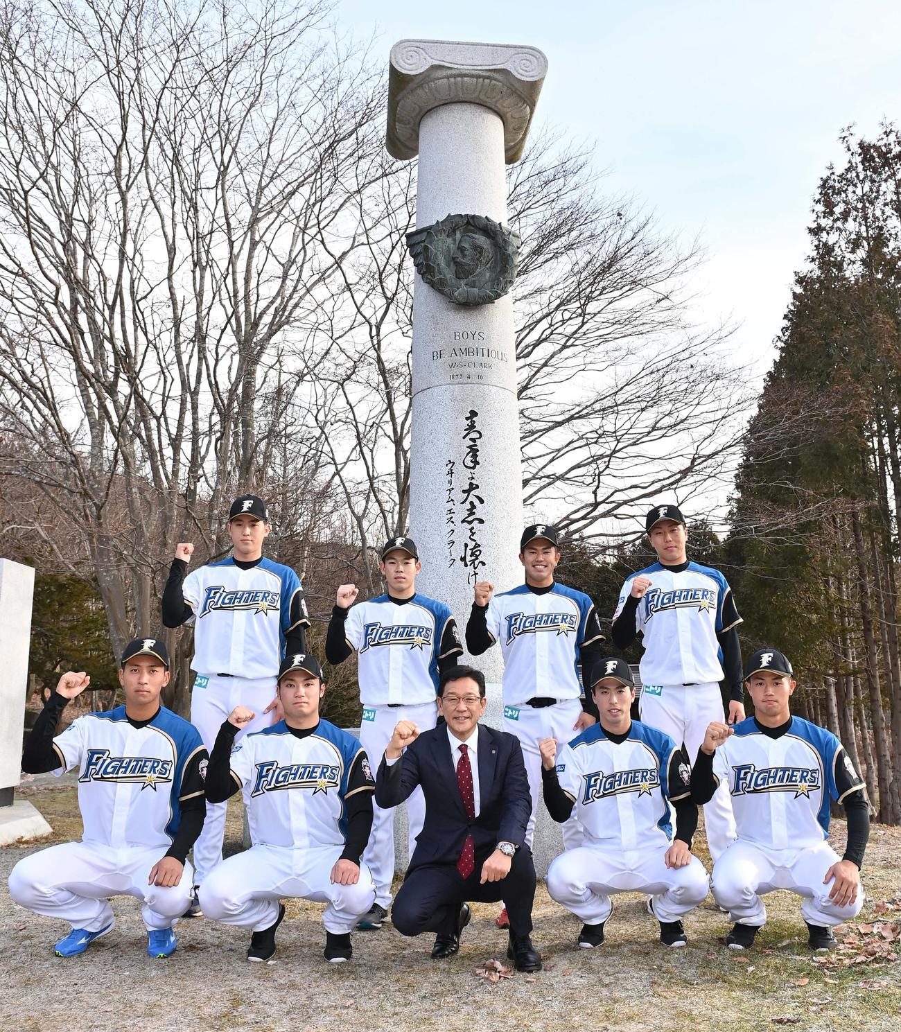 旧島松駅逓所前のクラーク博士の記念碑の前で意気込む前列左から古川、伊藤、栗山監督、五十幡、細川、後列左から松本遼、根本、今川、斉藤（代表撮影）