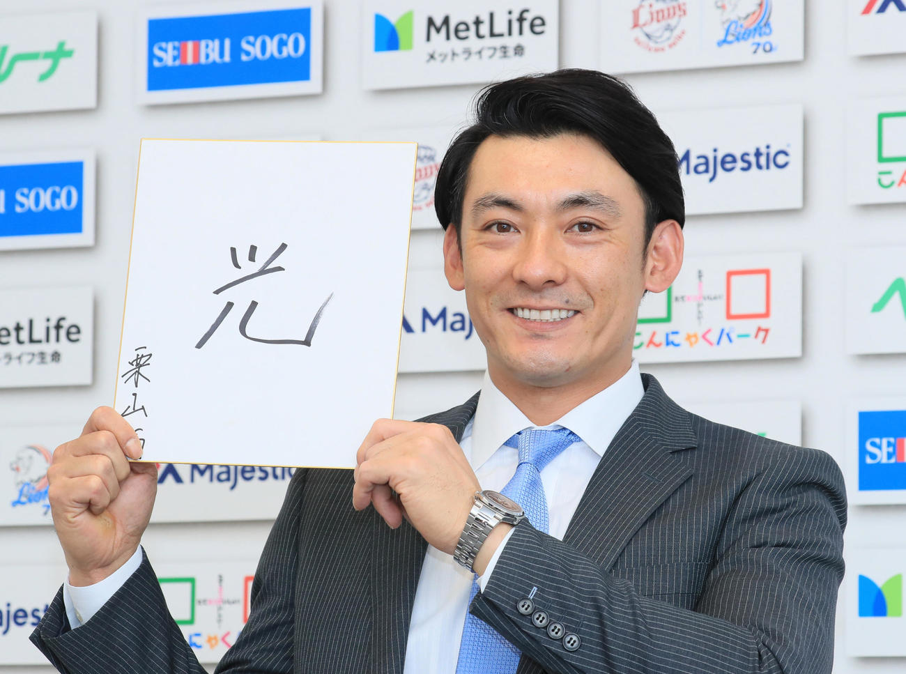 今年の漢字を「光」と記し、笑顔を見せる西武栗山（代表撮影）