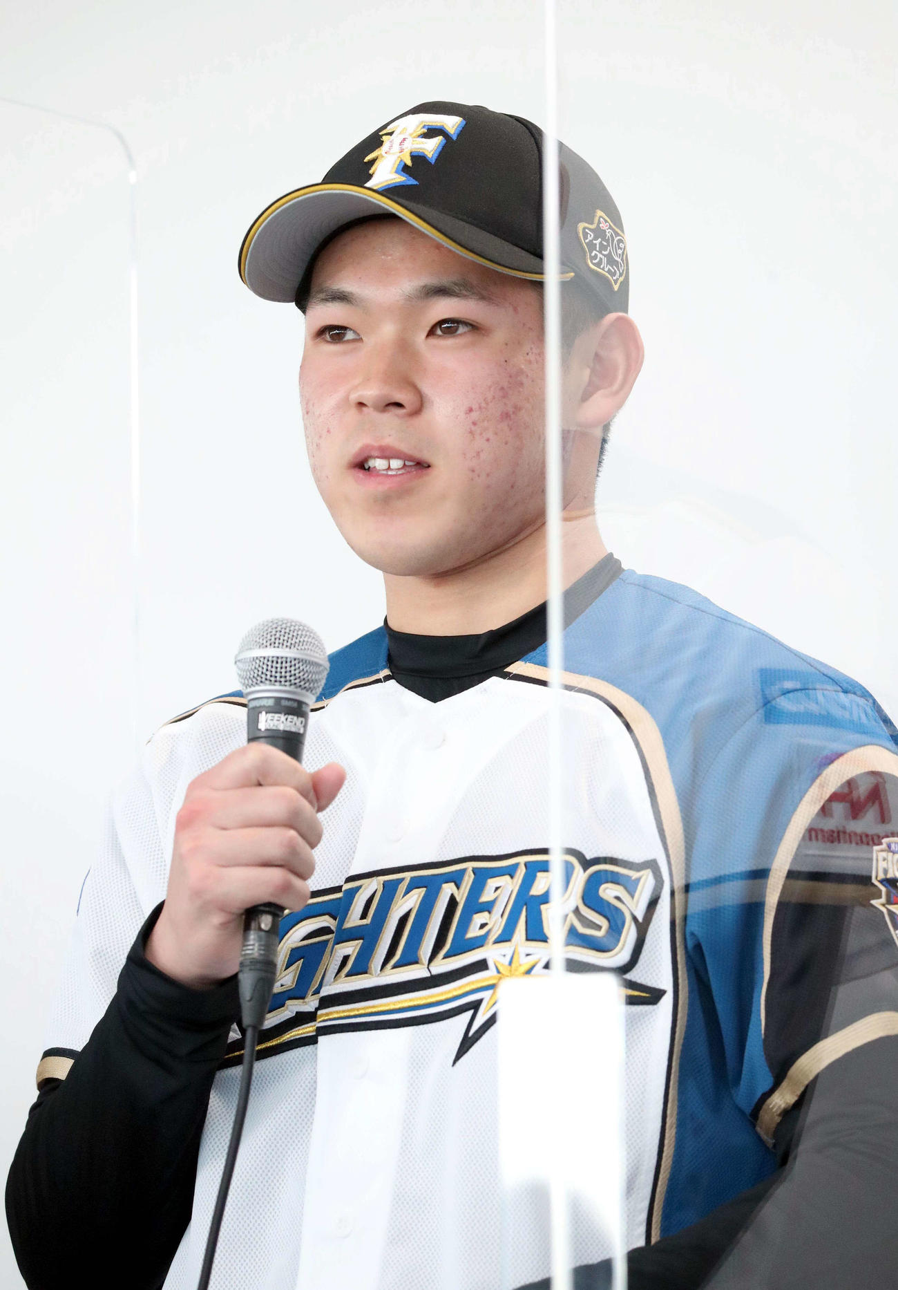 新入団選手発表会見で笑顔であいさつする日本ハム5位の根本（撮影・佐藤翔太）