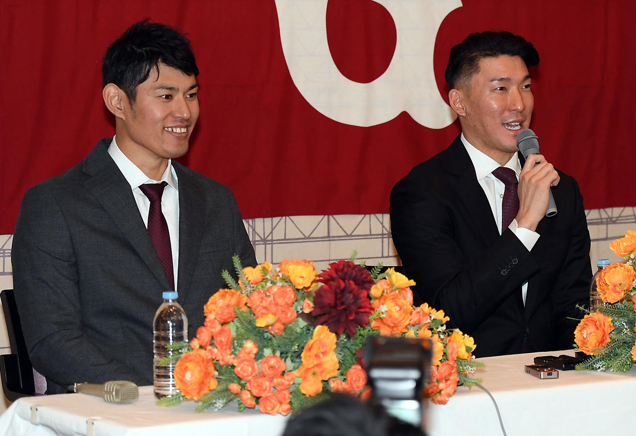 巨人の入団会見で笑顔で記者の質問に答える井納翔一（左）と梶谷隆幸（撮影・たえ見朱実）