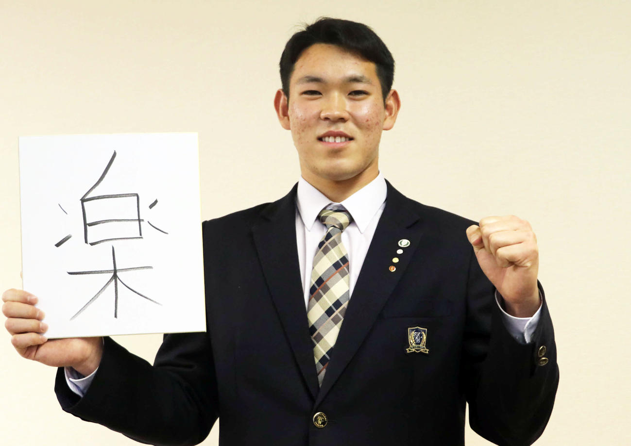 今年を表す漢字一字「楽」を色紙に書き入れた日本ハムドラフト5位の根本（撮影・山崎純一）