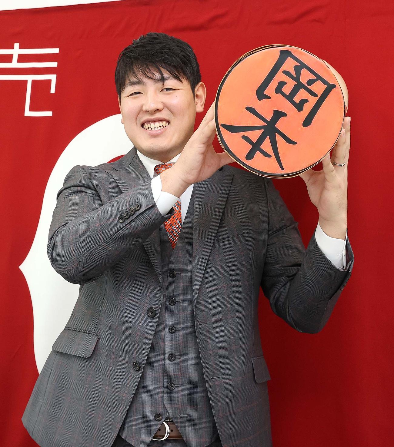 巨大な印鑑を抱える巨人岡本（球団提供）