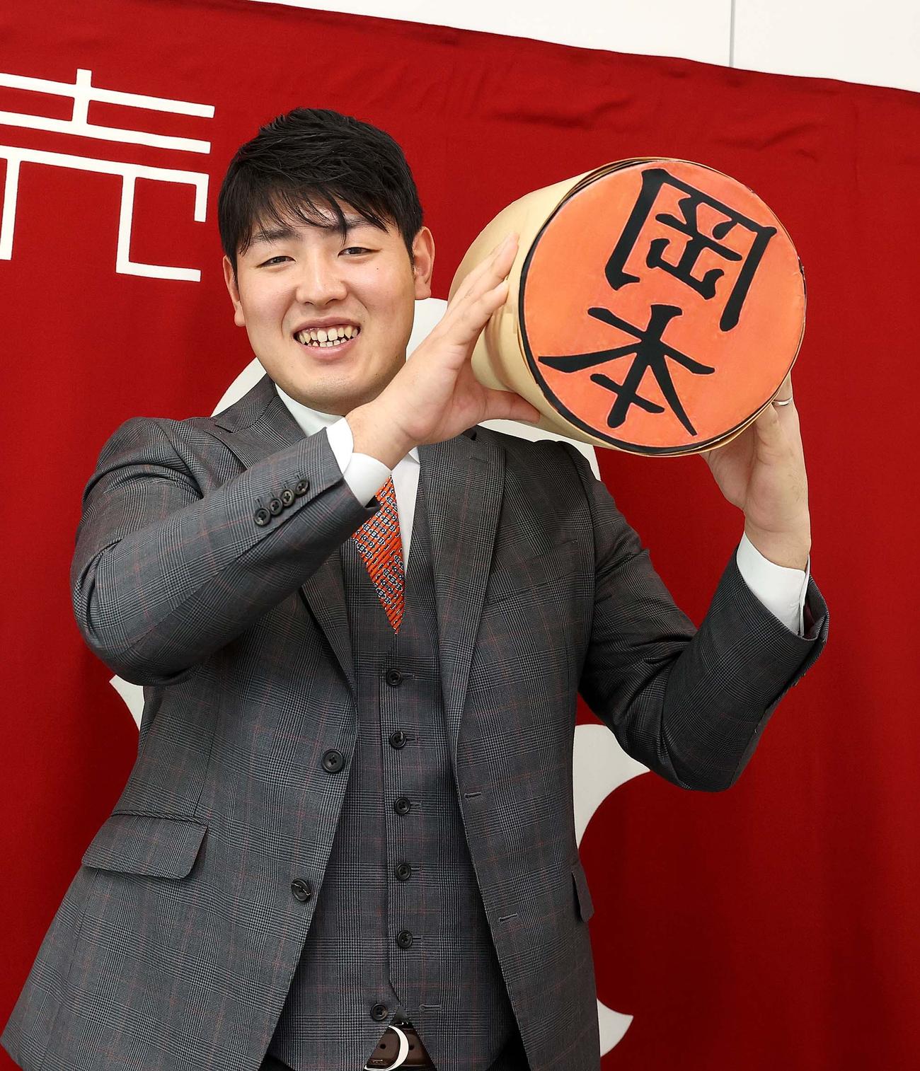 巨大な印鑑を抱える巨人岡本（球団提供）