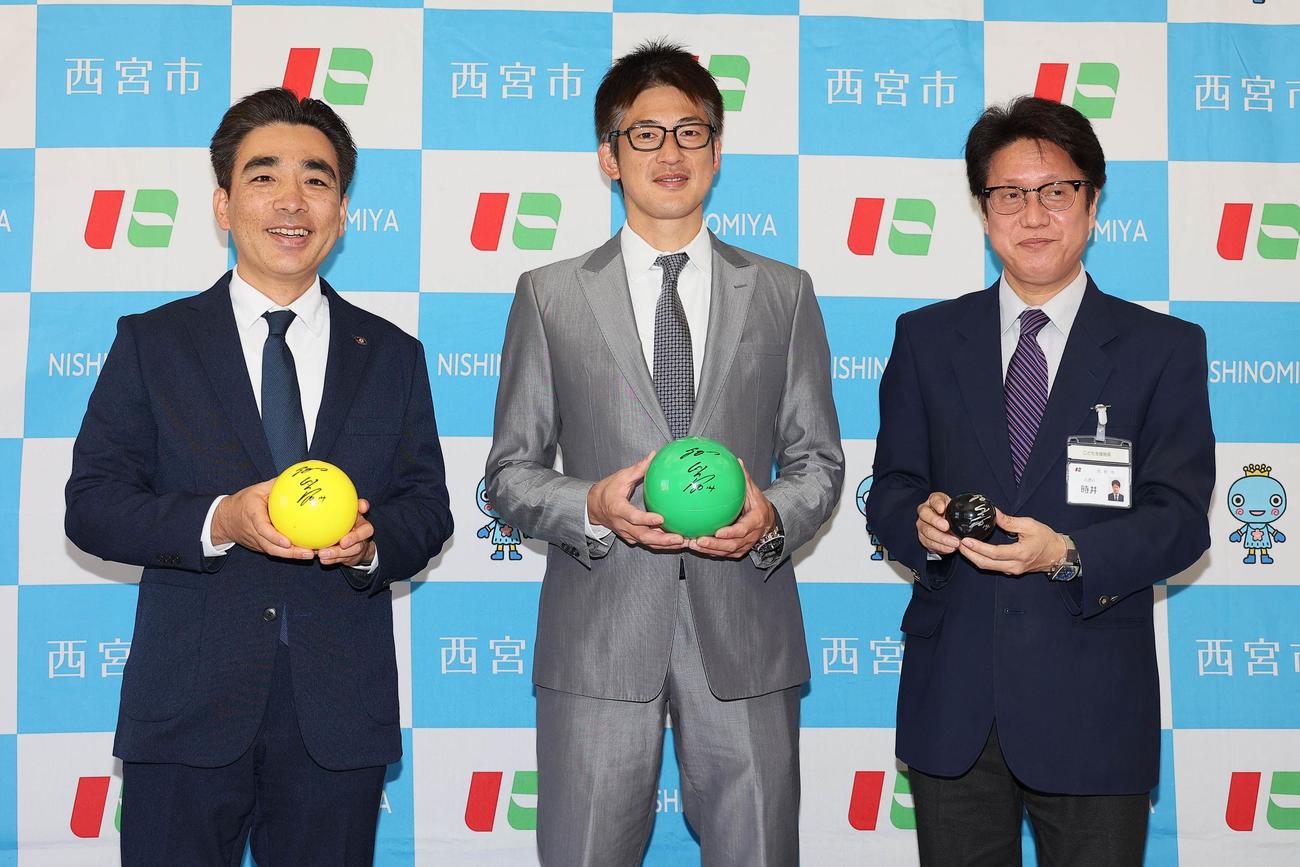 玩具寄贈式で、石井登志郎・西宮市長（左）、時井一成・西宮市こども支援局長（右）と共に記念写真におさまる能見篤史（代表撮影）