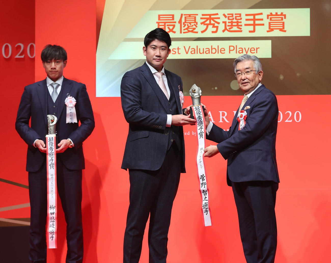 「NPB　AWARDS　2020」最優秀選手賞を受賞しNPB斉藤コミッショナーから表彰を受ける巨人菅野。左はソフトバンク柳田（代表撮影）