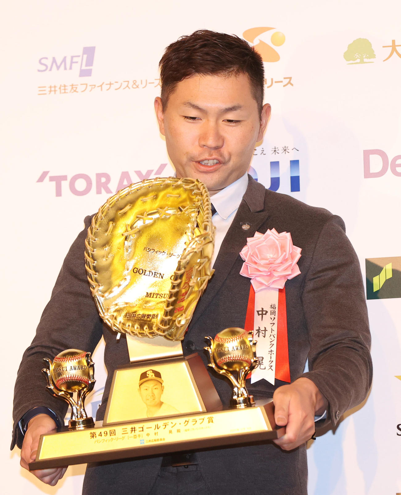 「三井ゴールデン・グラブ賞」を受賞し、トロフィーの重さに驚く中村（撮影・狩俣裕三）