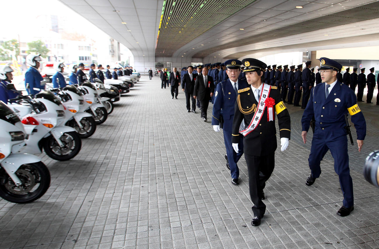 12年11月、甲子園警察署の1日署長を務めた上本は警察官を装備品をチェック