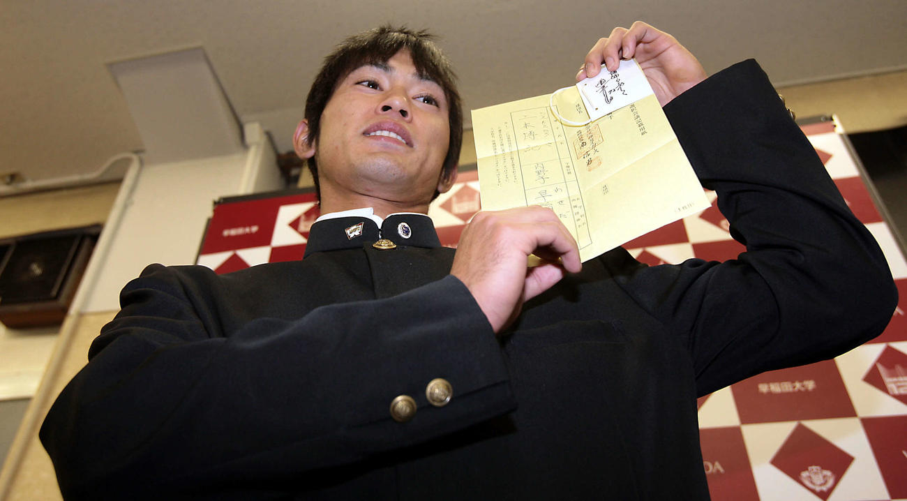 08年11月、ドラフトの指名用紙と真弓監督のサインを手に笑顔を見せる早大・上本