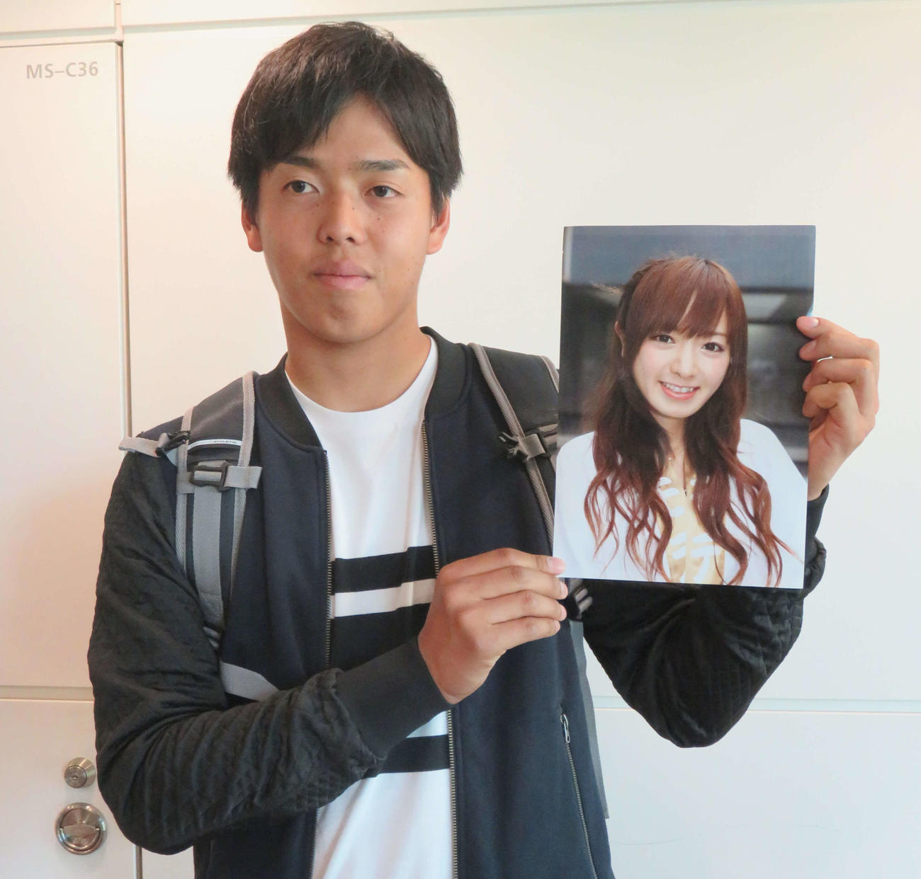 17年1月、結婚したテレビ東京の紺野あさ美アナウンサーの写真を手に笑顔を見せる杉浦