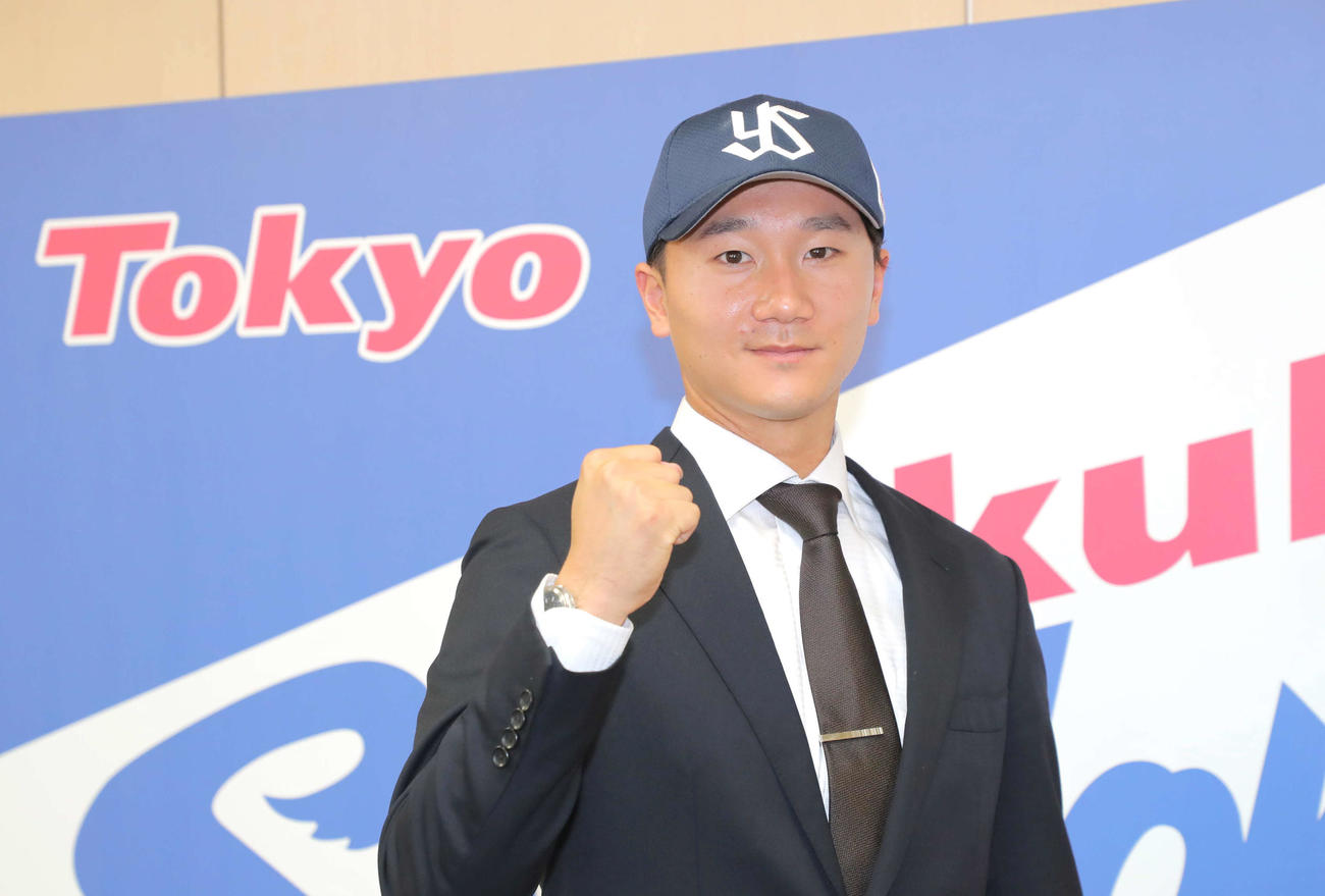 入団会見後、ヤクルトの帽子をかぶりガッツポーズする宮台（代表撮影）