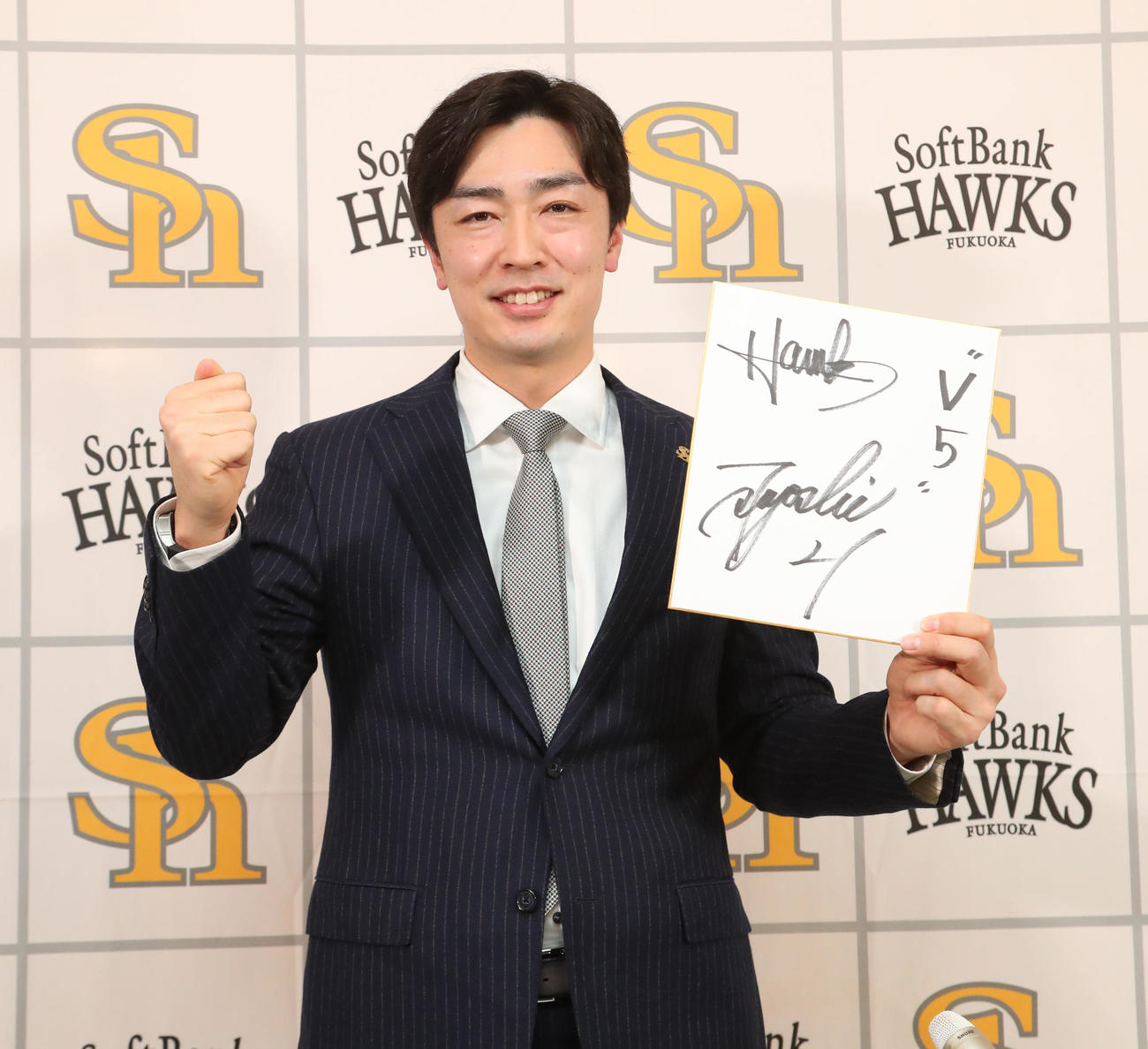 契約更改を終えた和田毅は「V5」と色紙に記し笑顔を見せる（撮影・梅根麻紀）