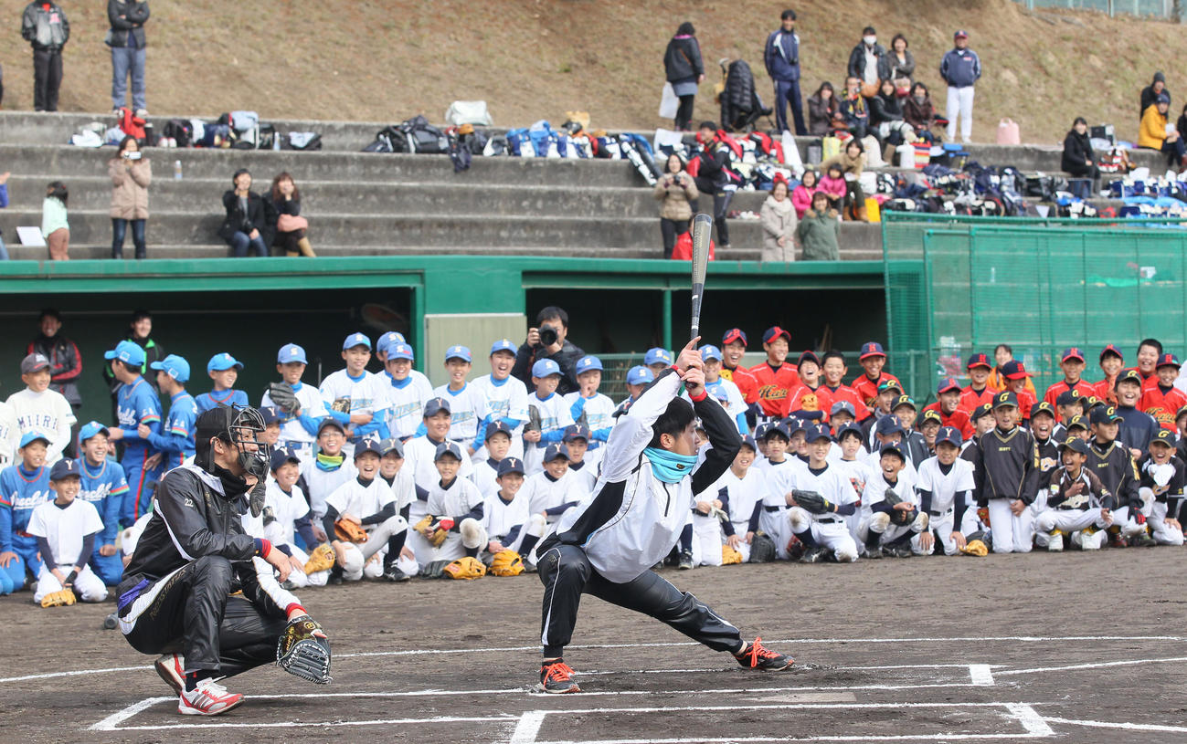 14年12月、大勢の子どもたちが注目する中、兄博紀の打撃フォームをまねて笑いを誘う広島上本