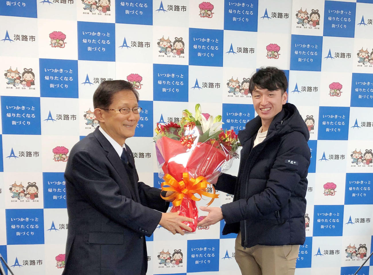 門康彦淡路市長（左）を表敬訪問し花束を受け取る近本（淡路市提供）