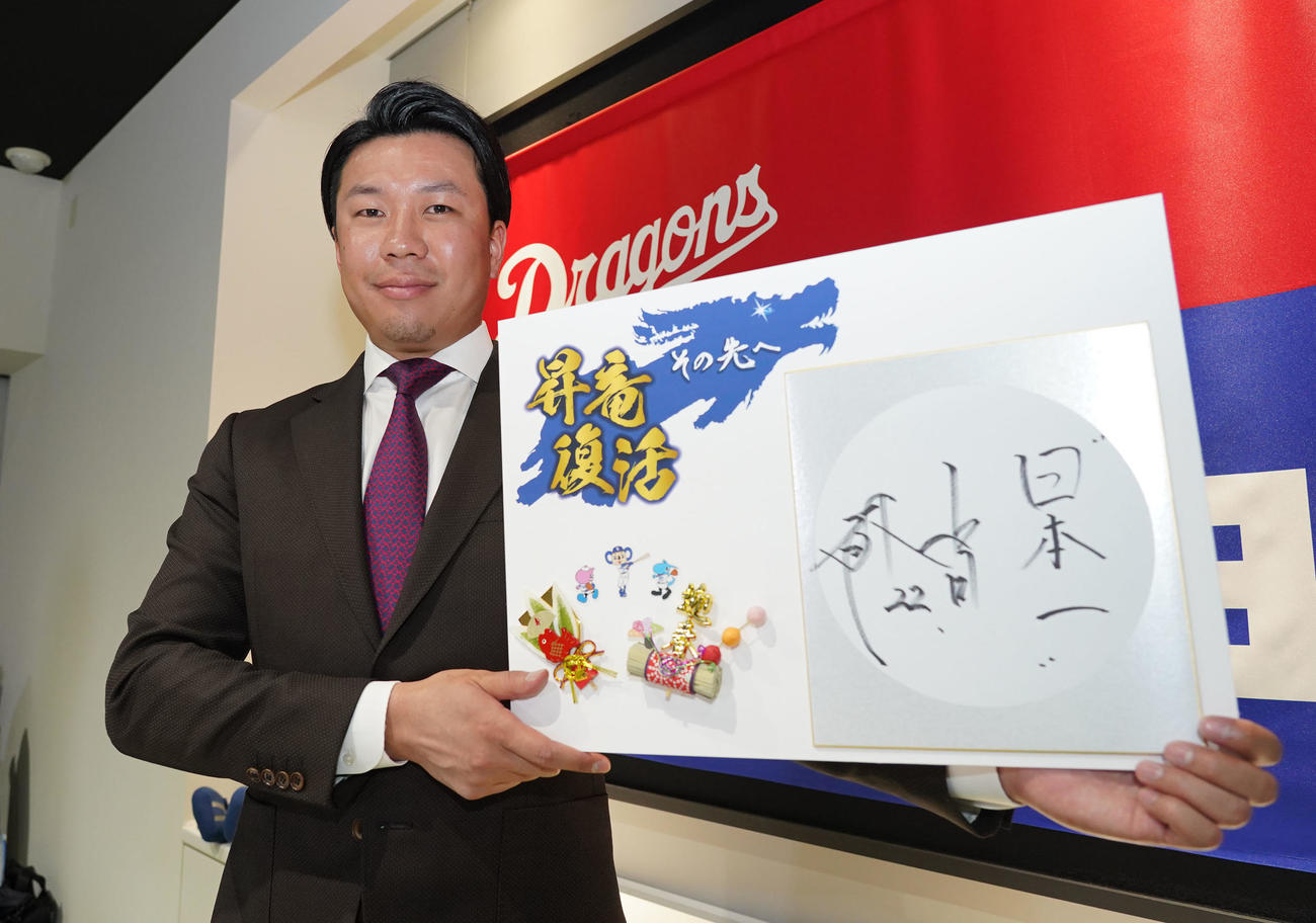 来季のチームスローガンと目標の「日本一」を記したボードを手にする大野雄（撮影・森本幸一）
