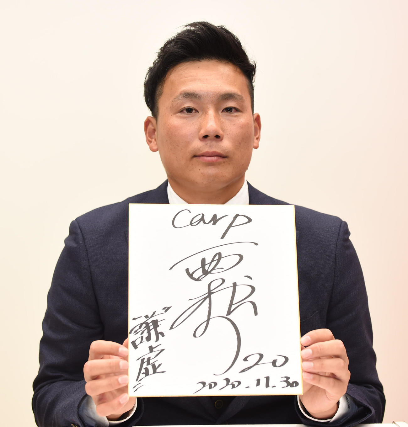 広島と仮契約を済ませた栗林は、色紙に背番号「20」と「謙虚」を書き込む（2020年11月30日）
