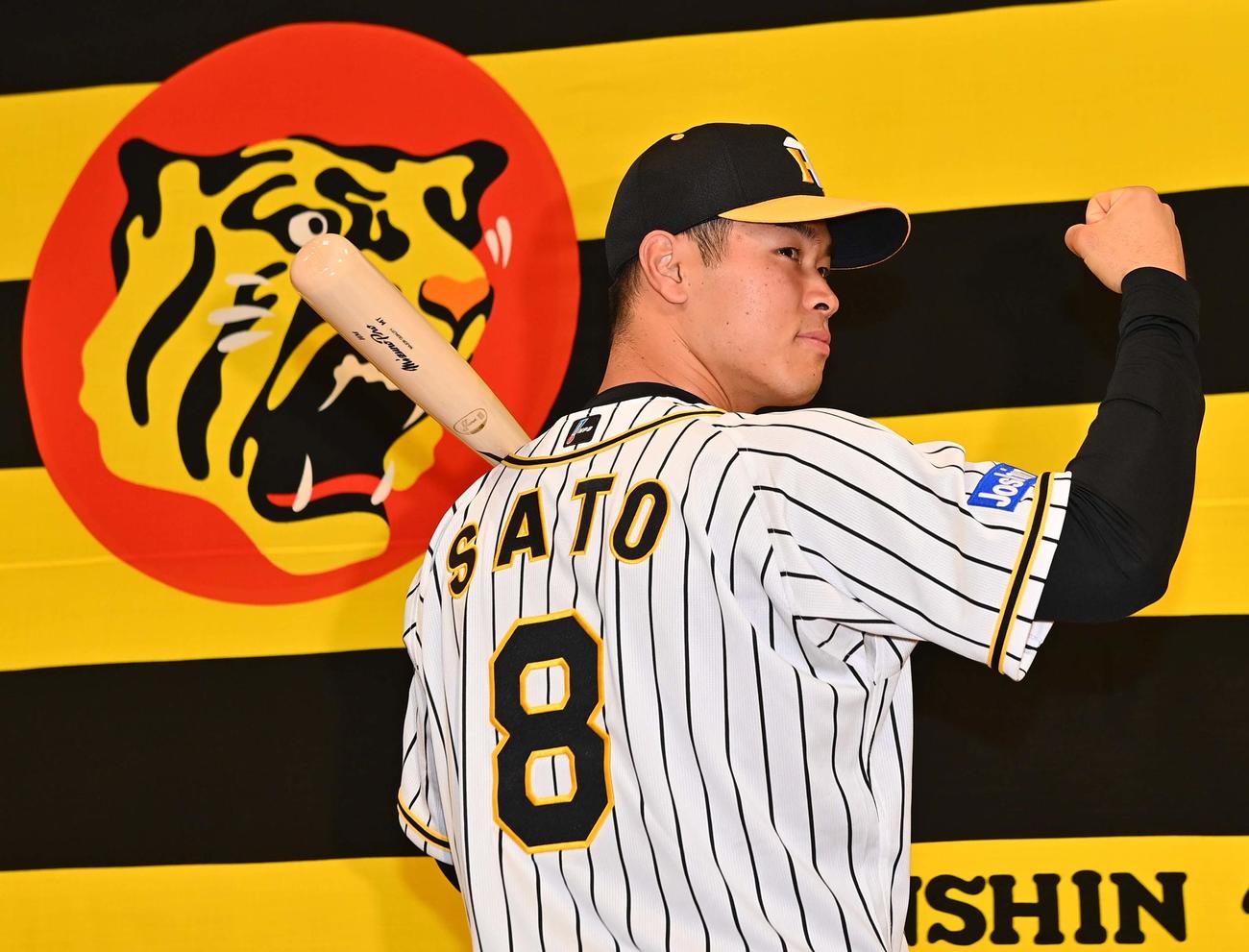 阪神新人選手入団発表会でバットを背に背番号8を披露するドラフト1位の佐藤輝明（2020年12月7日撮影）
