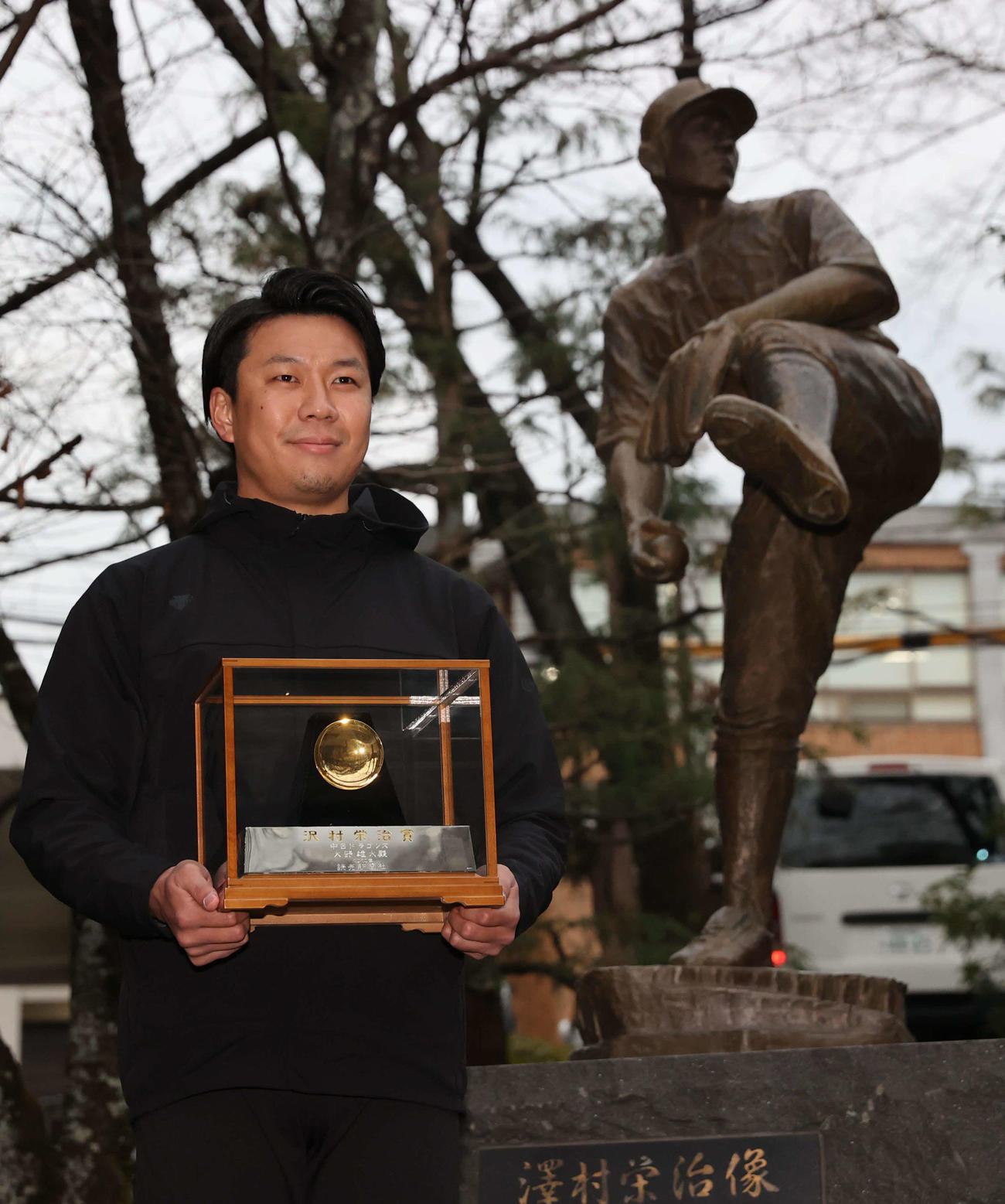 沢村賞の金杯を持って京都学園（旧京都商）の沢村栄治銅像に受賞報告する中日大野雄（代表撮影）