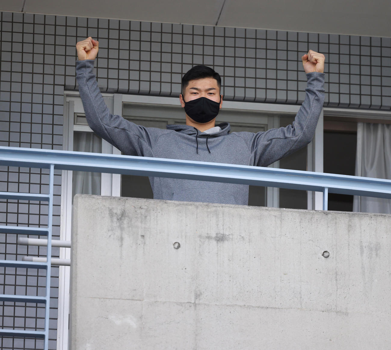 虎風荘に入寮しベランダに出てポーズを取る阪神ドラフト1位の佐藤輝明（球団提供）