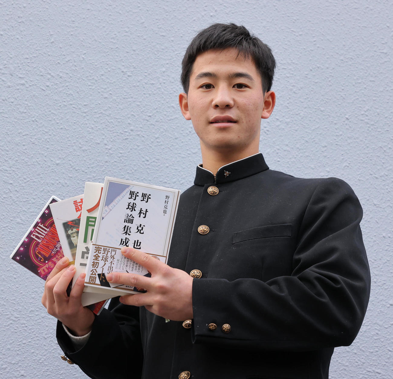 野村克也氏らの本を持って入寮する内山壮真（代表取材）