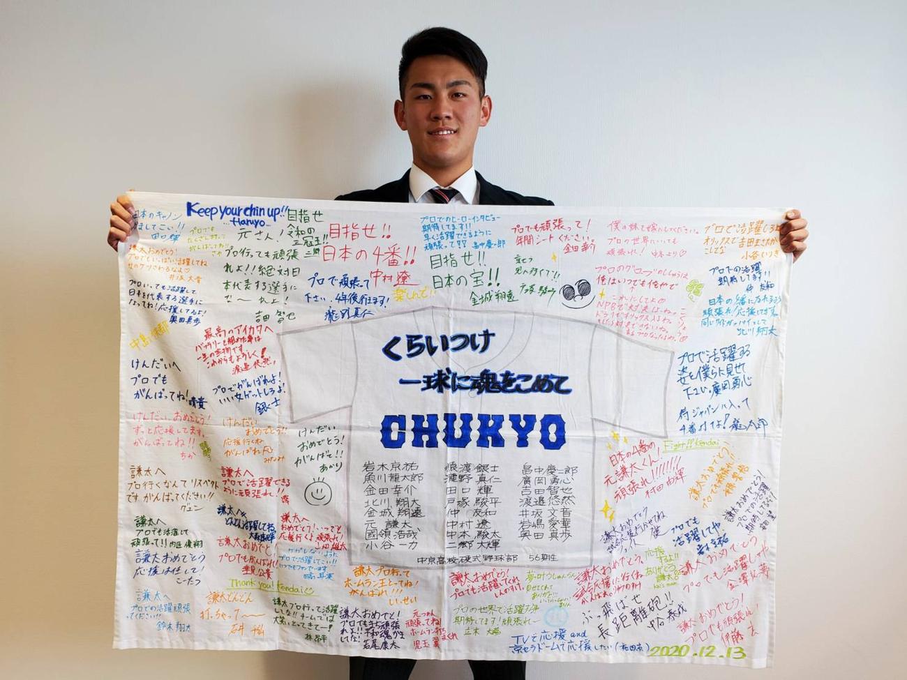 中京の友人から贈られた寄せ書きを広げるオリックス元（球団提供）
