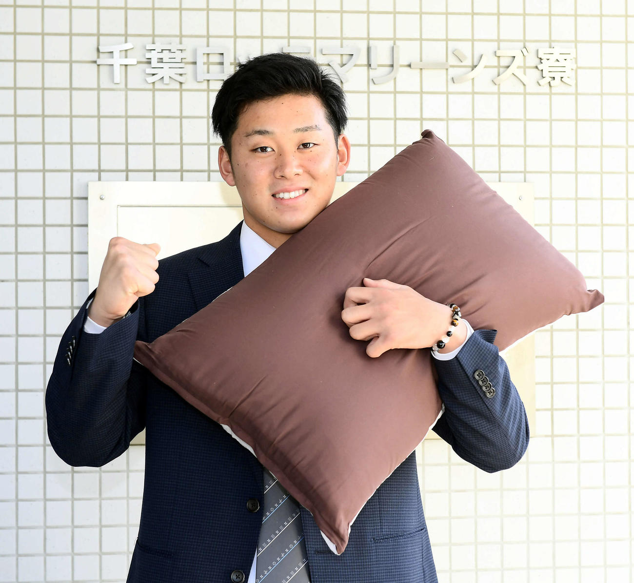 持参した枕を手にするドラフト1位の鈴木（代表撮影）
